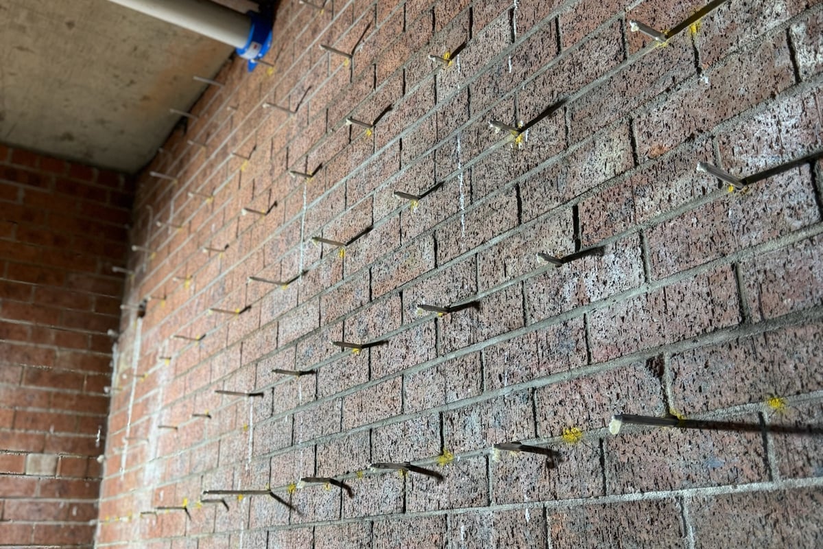 Injection points finished flush and color-matched to facade surface